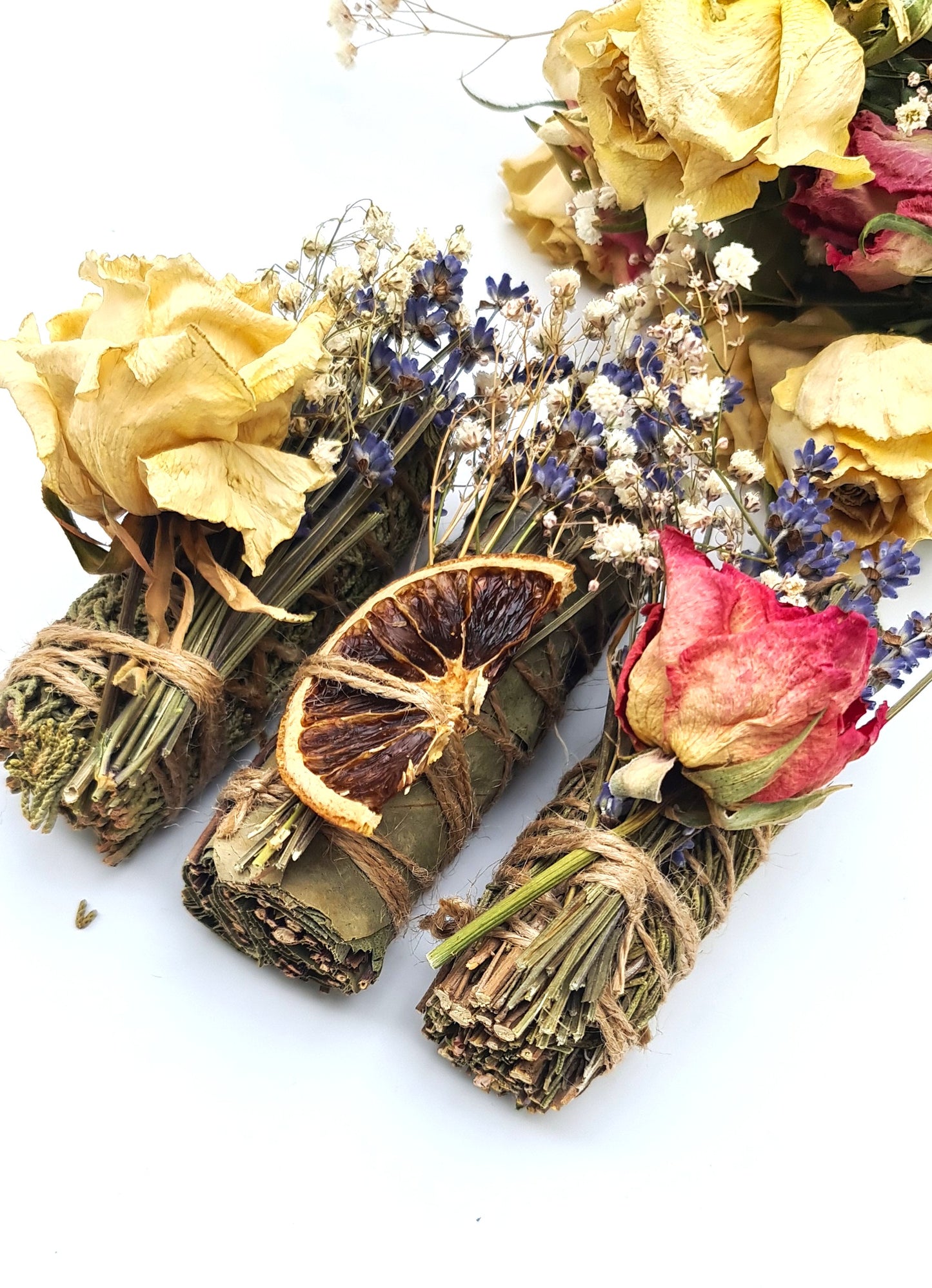 Bundles of dried herbs and flowers on a white background